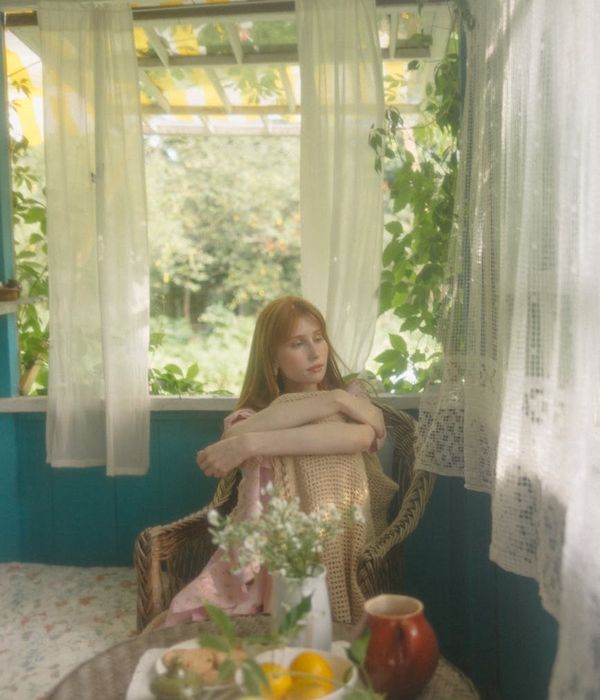 A person stretching gently by a window, looking peaceful and refreshed.